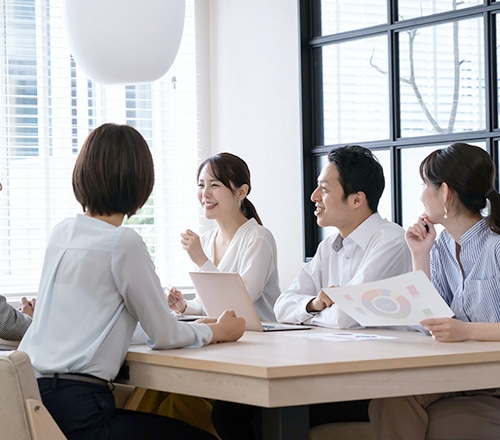 笑顔で資料を見ながらミーティングをするビジネスパーソンたち