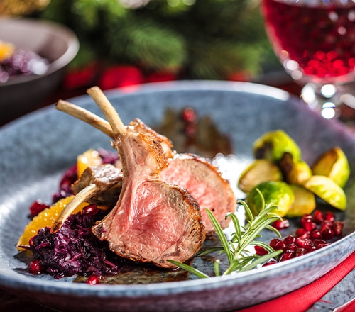 皿に美しく盛り付けられた骨付きラム肉とローズマリーの料理